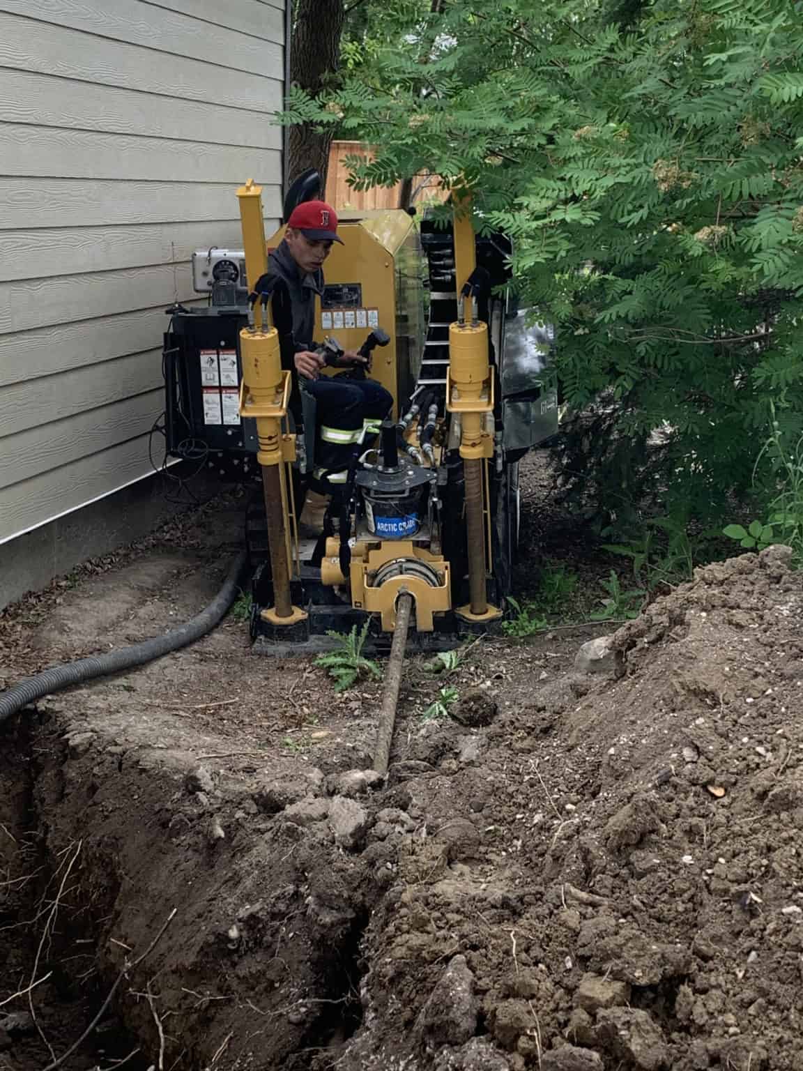 Compact directional drill working beside a home