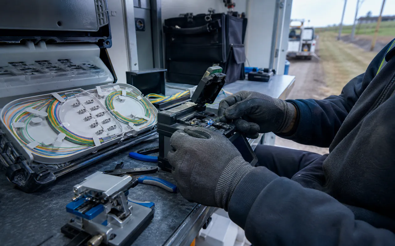 Technician aligning fibre optic strands in a fusion splicer